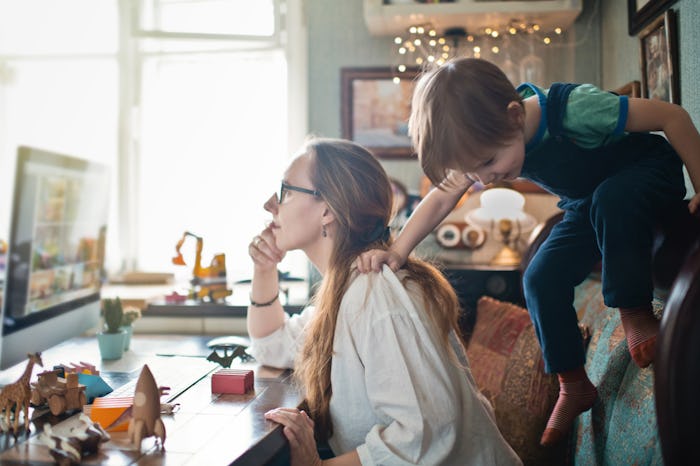 mom trying to work at home while son climbs on chair
