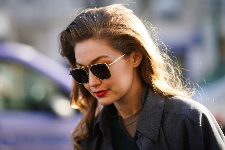 Gigi Hadid steps out in a gray blazer and aviator sunglasses.