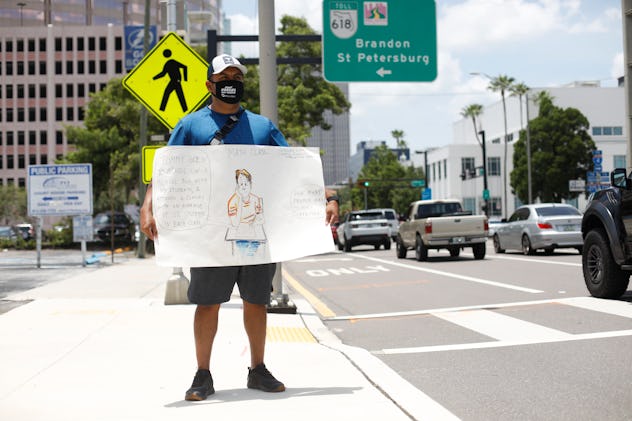 A teacher holds up a sign to protest schools reopening in Florida.