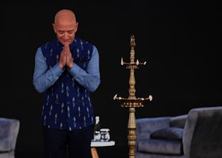 Jeff Bezos bows on stage during a trip to India.