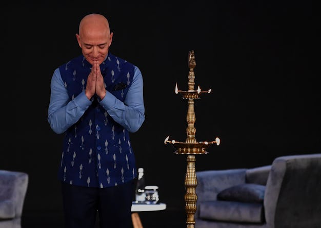 Jeff Bezos bows on stage during a trip to India.