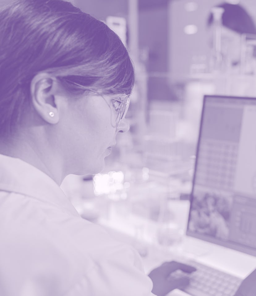 A female scientist or medical researcher using a desktop computer.