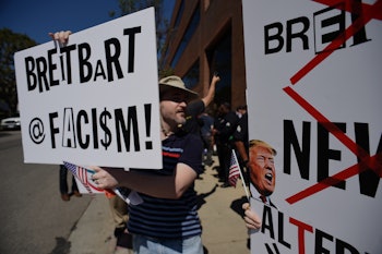Protestors hold up signs equating Breitbart to fascism and fake news. 