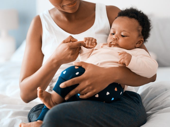 A mom holding her baby in her lap while thinking about nickelodeon-themed baby names