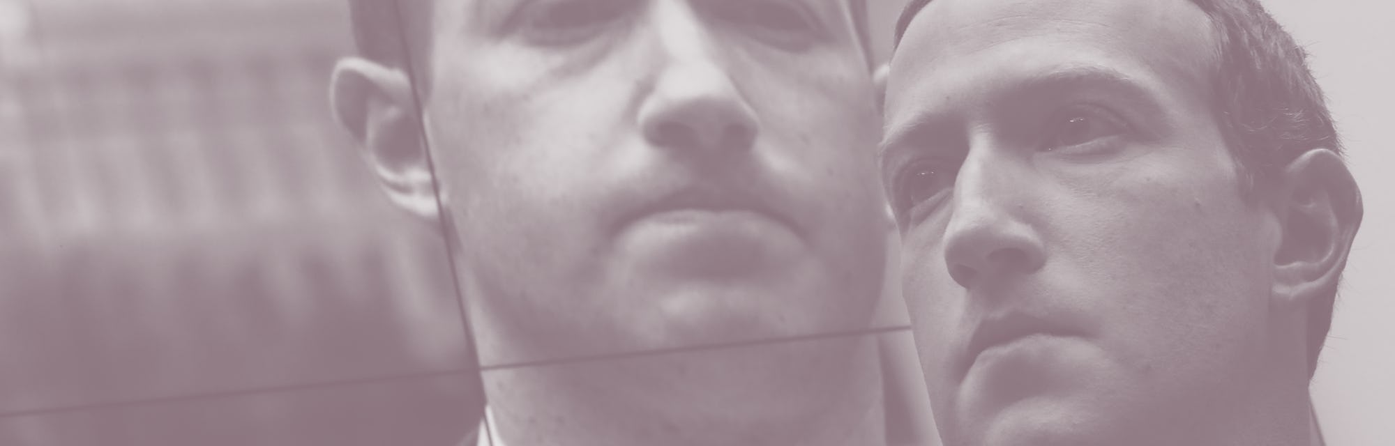 Mark Zuckerberg in front of a screen showing a picture of him frowning.