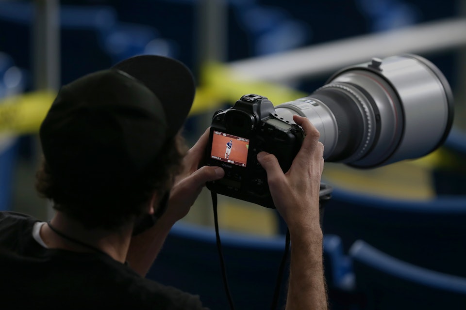 Photographer holding a DSLR camera.