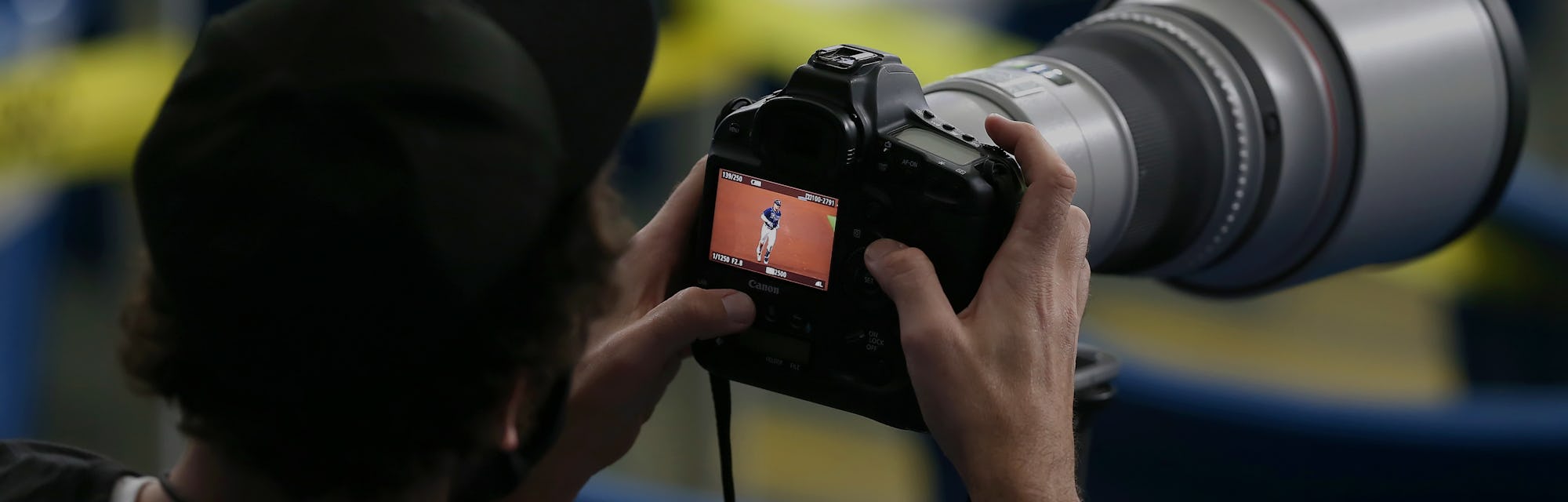 Photographer holding a DSLR camera.