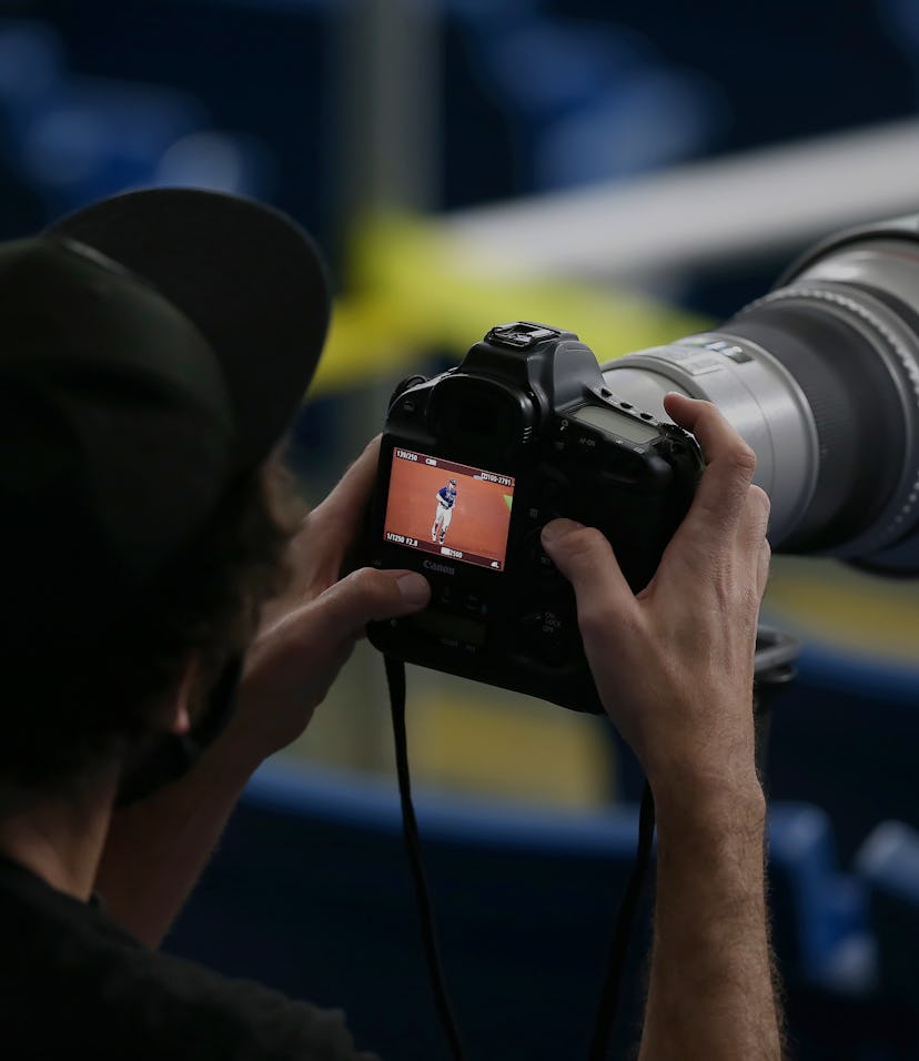 Photographer holding a DSLR camera.