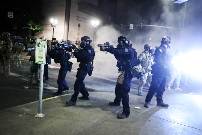 Armed police officers can be seen inching forward in Oregon during Black Lives Matter protests.