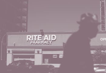 A pedestrian can be seen walking in front of a Rite Aid store.