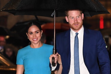 Prince Harry and Meghan Markle share an umbrella.