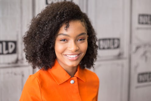 Yara Shahidi poses in an orange shirt