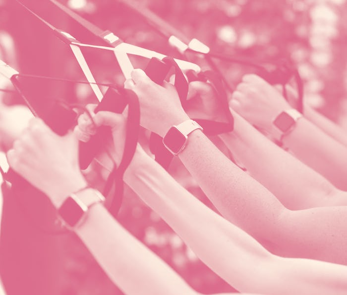 A row of arms wearing Fitbits while exercising.