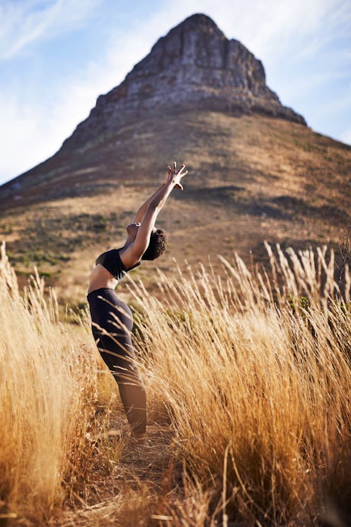 A woman does yoga in front of a rock face. Global day of unplugging 2020 on August 1 is a chance to ...