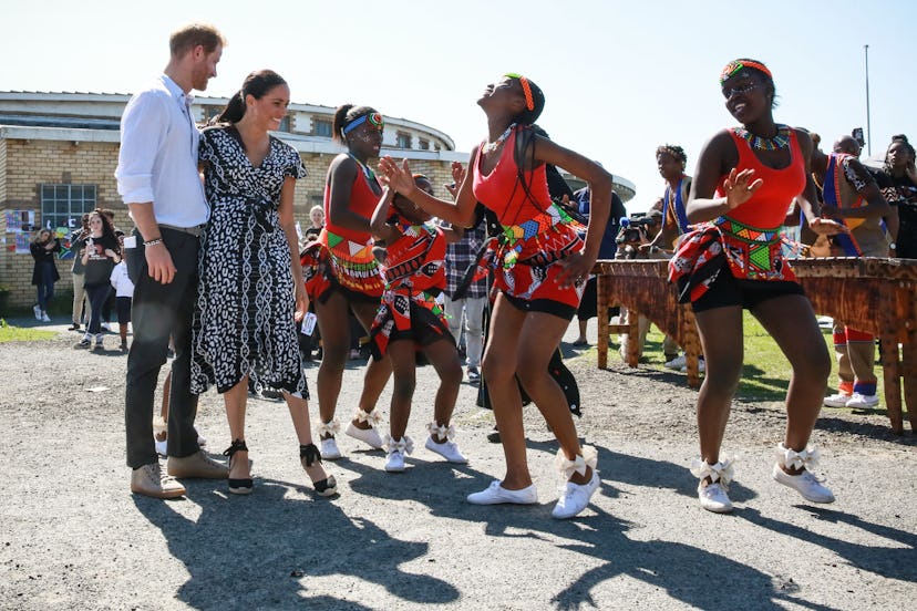 Prince Harry supports Meghan Markle as she dances in Africa.