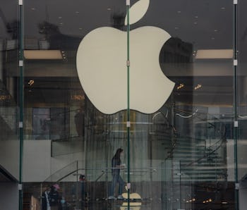 The Apple logo can be seen in the window of an Apple Store.