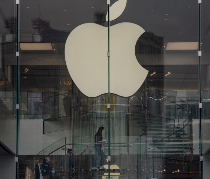 The Apple logo can be seen in the window of an Apple Store.