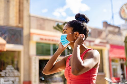 A woman wears a mask while running errands. New research shows that patients are experiencing long-t...