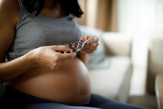 pregnant woman opening vitamins
