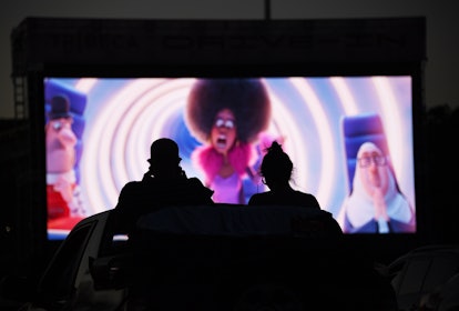 A couple watches a movie at the drive-in.