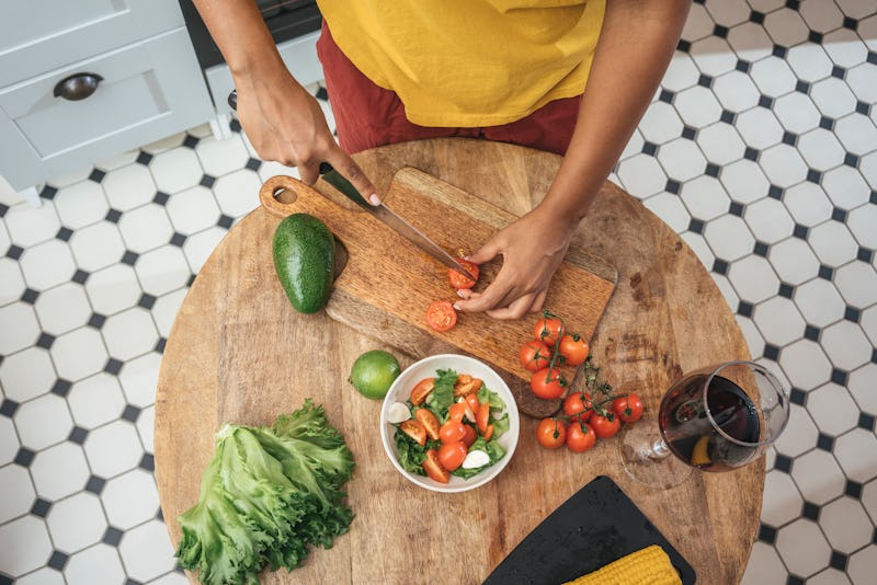 A woman makes a salad. These are the vitamins you might be lacking if you're having trouble sleeping...