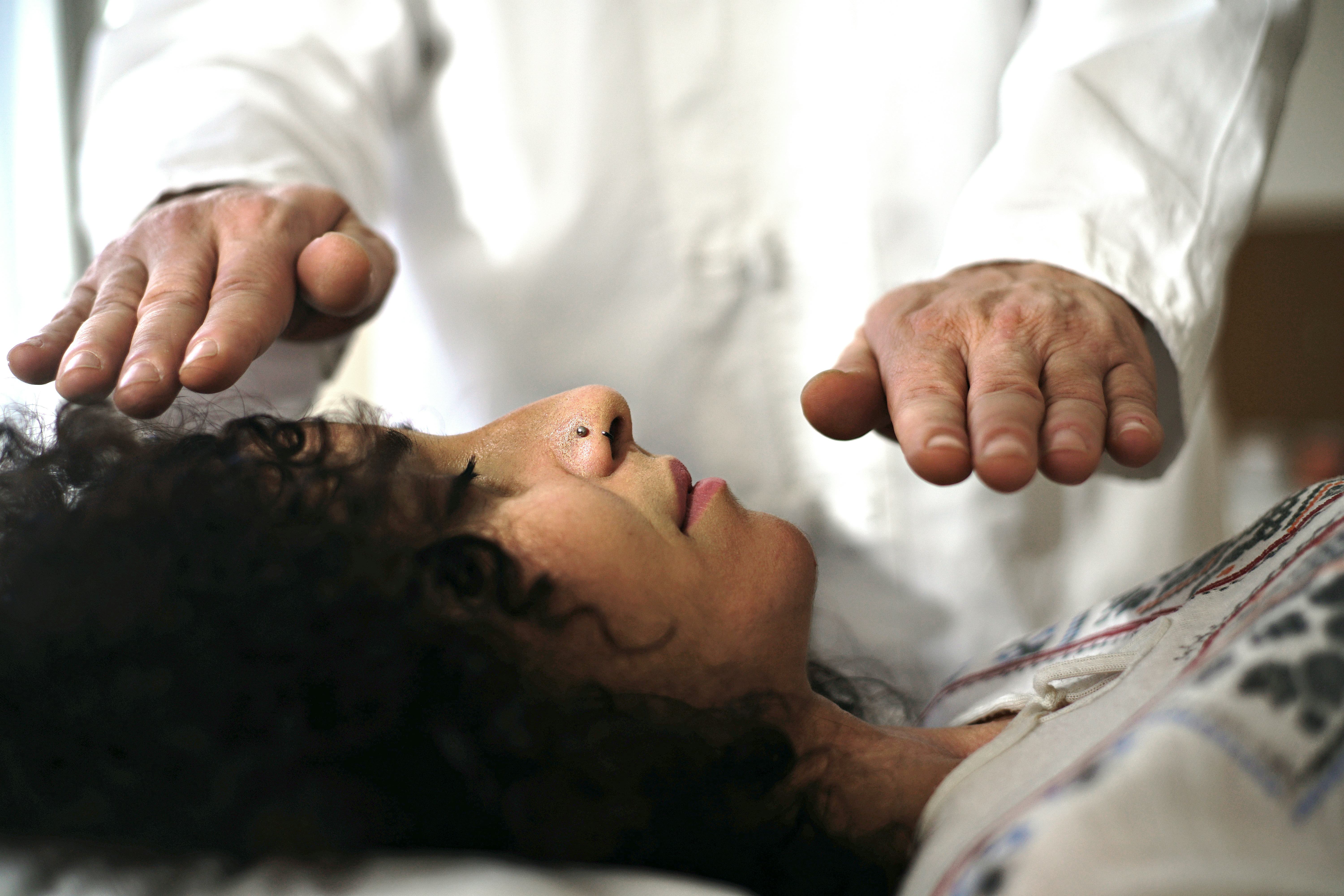 A woman receives reiki healing. Reiki is an alternative therapy originating in Japan.