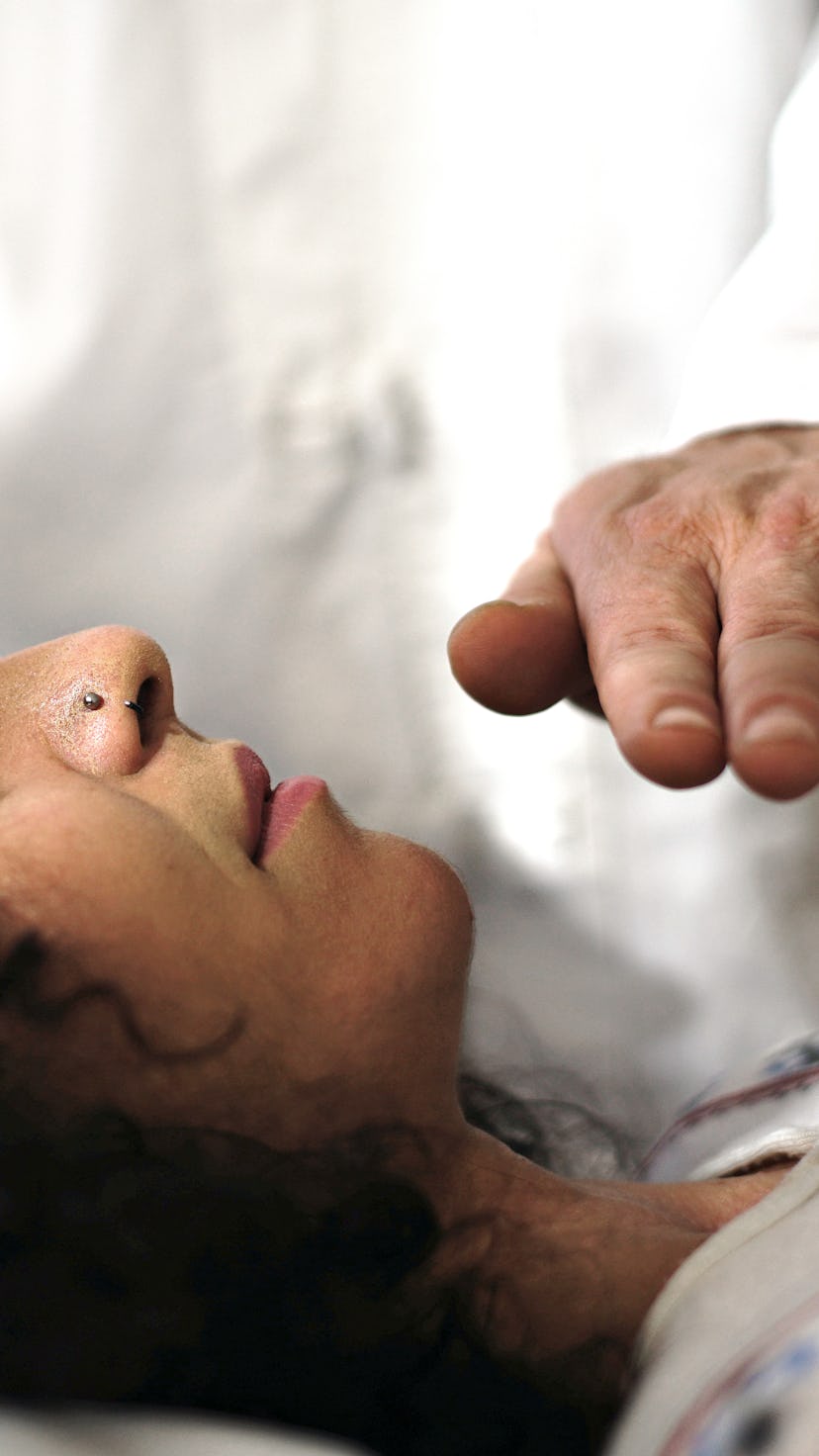 A woman receives reiki healing. Reiki is an alternative therapy originating in Japan.
