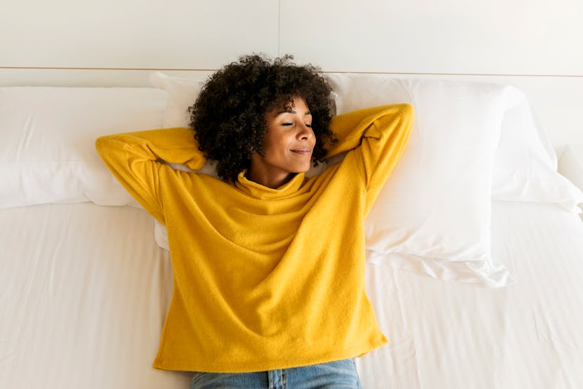 A woman sleeps in a yellow shirt. Here's what recurring dreams do to your brain.
