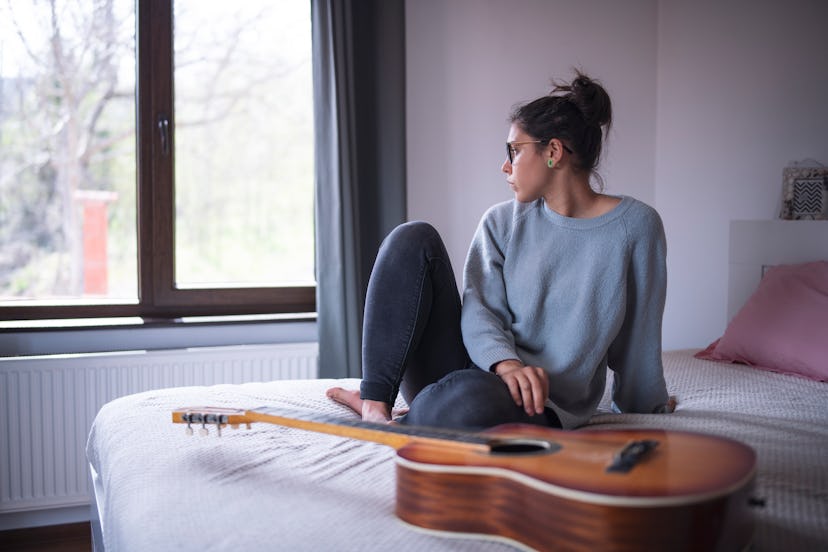 A woman with a guitar stares out a window. If you've had a scary dream, these techniques can help yo...