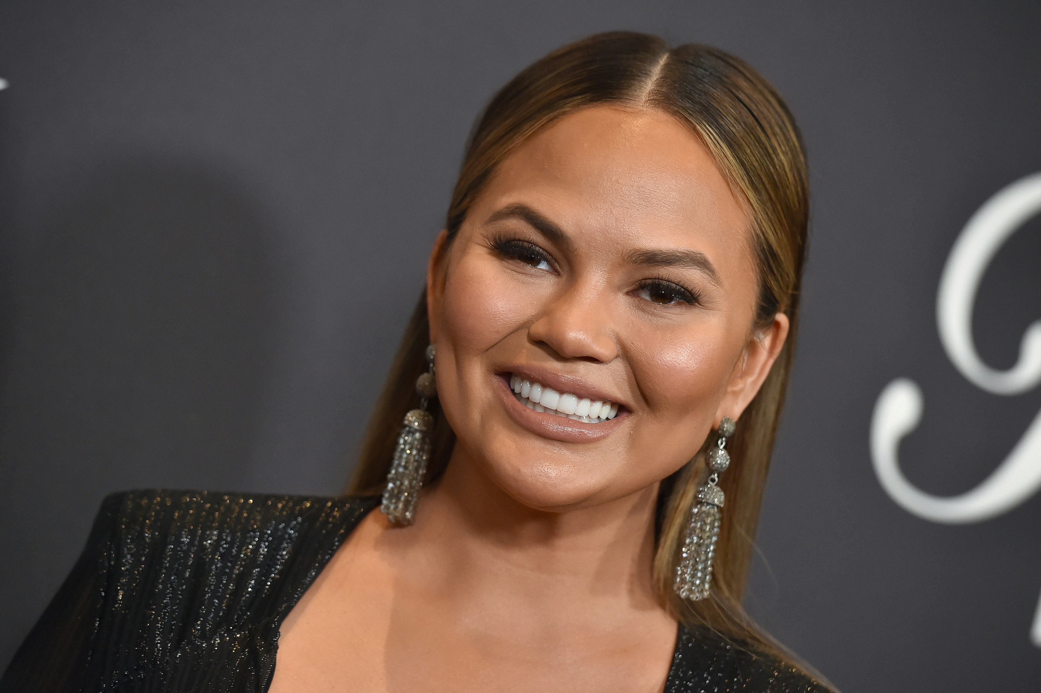 Chrissy Teigen poses on the red carpet