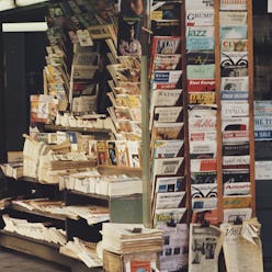 Close-up of a news stand with magazines and newspapers.