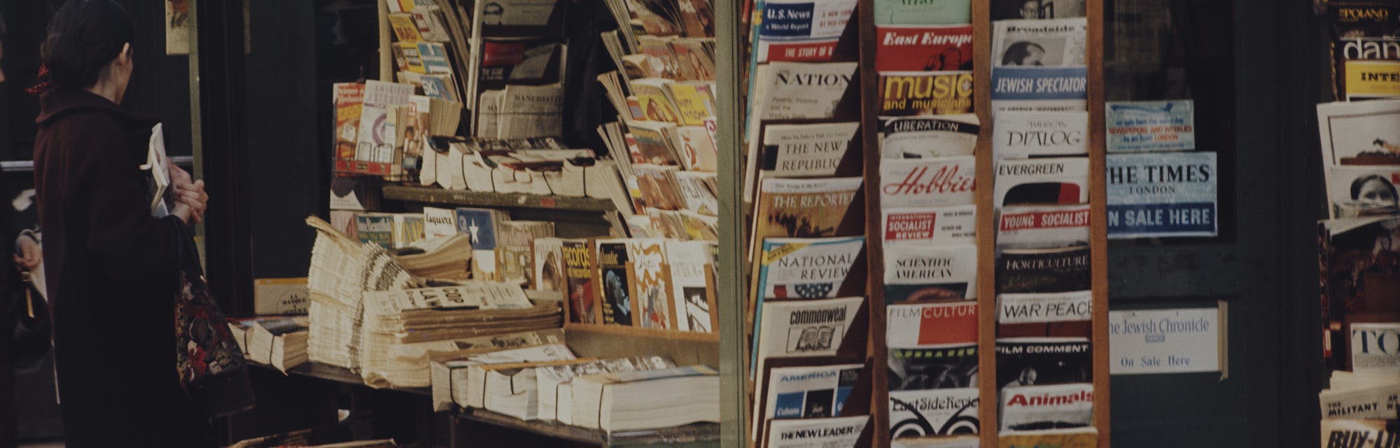 Close-up of a news stand with magazines and newspapers.