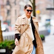 Katie Holmes wearing a beige trench coat while walking in New York City.