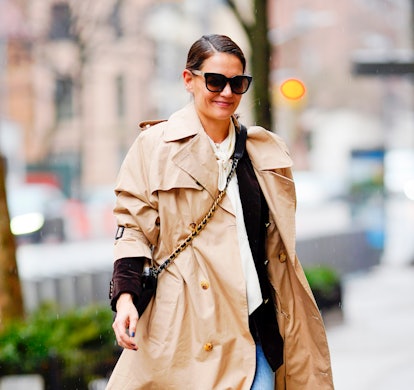 Katie Holmes wearing a beige trench coat while walking in New York City.