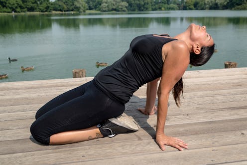 A person performs a backbend outside along a waterfront. Certain yoga flows are especially helpful f...