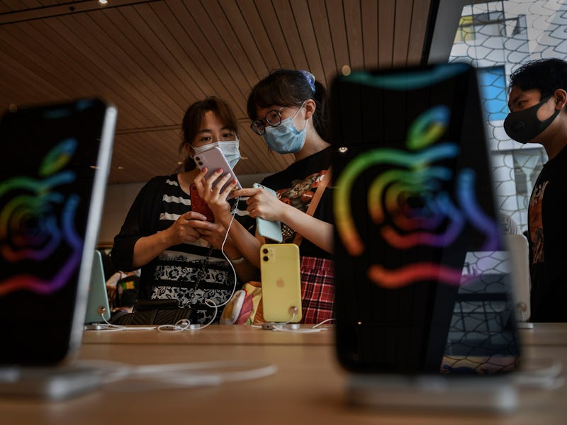 Two people examine an iPhone at an Apple Store in China.