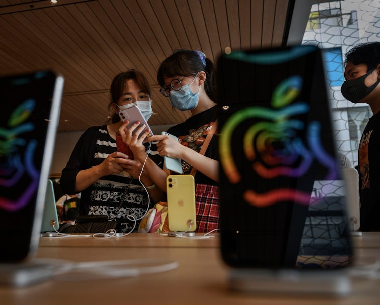 Two people examine an iPhone at an Apple Store in China.