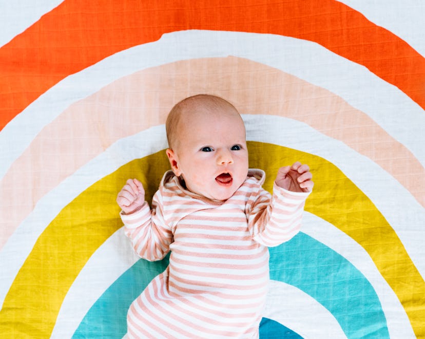 These Rainbow Baby Day quotes are the sweetest; baby on rainbow sheet