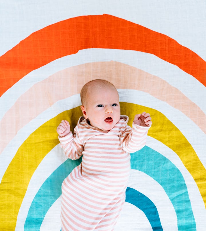 These Rainbow Baby Day quotes are the sweetest; baby on rainbow sheet