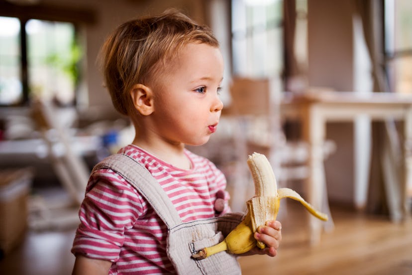 young child eating a banana as an after-school snack