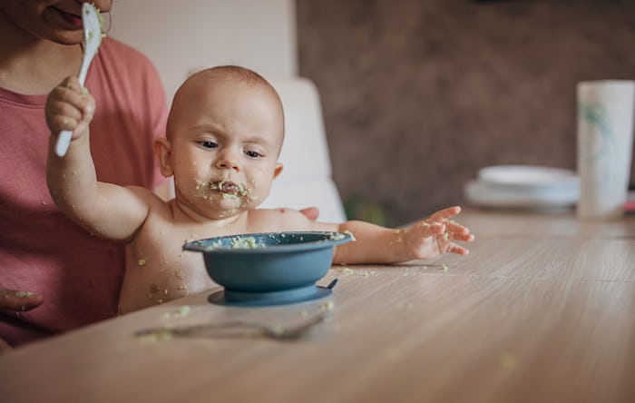 baby eating mashed avocado
