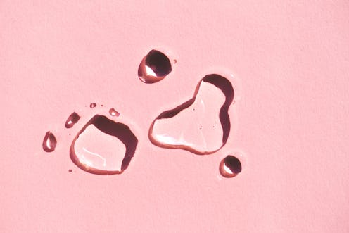 Water splashes on a pink background. These 8 essential oils cleanse negative energy, according to pe...