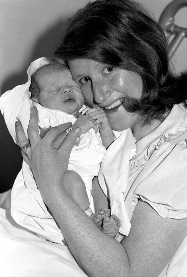 A mom holds her baby face-to-face in this vintage maternity ward photo.