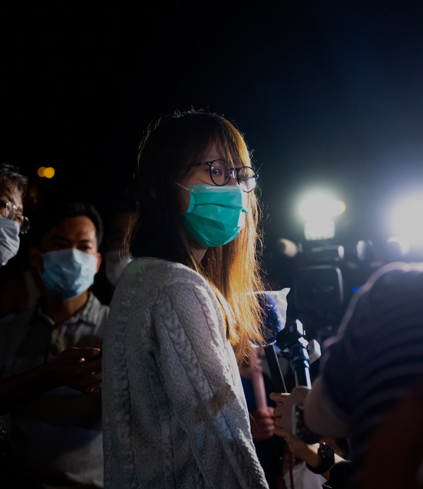 Activist Agnes Chow is lit by harsh lights as she's interviewed in Hong Kong.