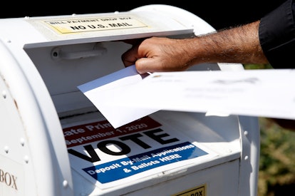 A man putting in his vote letter in a mailbox