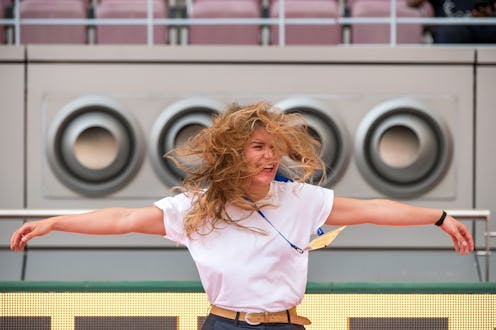 A woman stands in front of an industrial air conditioner. Does air conditioning affect your body? He...