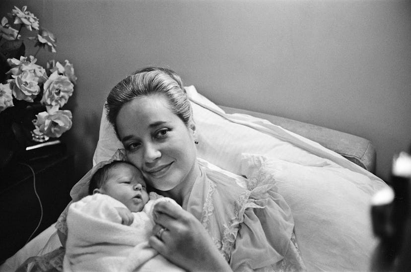 A mom holding her baby and smiling is pure bliss in this vintage maternity ward photo. 