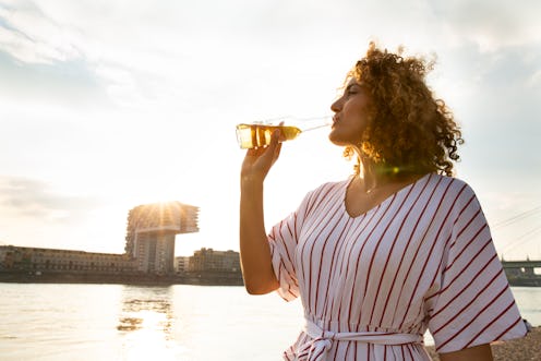 A woman drinks a beer while on the water. This article describes signs your body can't tolerate beer...