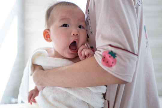 Asian girl baby in her mother's arms after bath