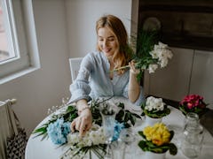 A woman arranging some flowers for a DIY craft at home. 